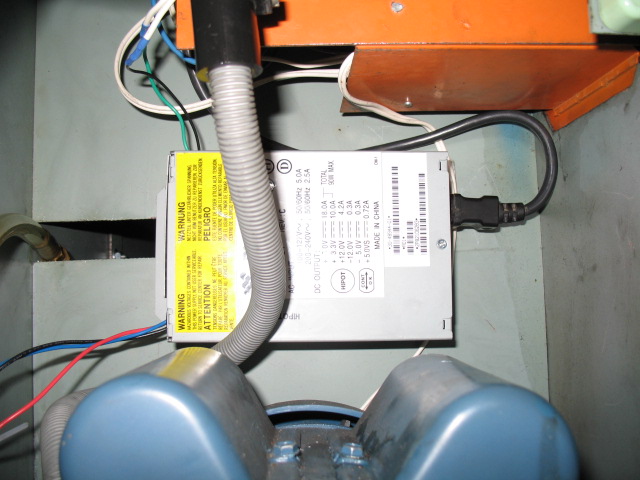 Shows the modified computer power supply fitted inside the cabinet above the motor.  A toggle switch is mounted on the front of the cabinet so I only runs when needed.